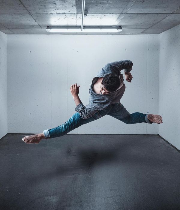 A man in athletic wear performing a focused strength exercise in a bright, modern space.